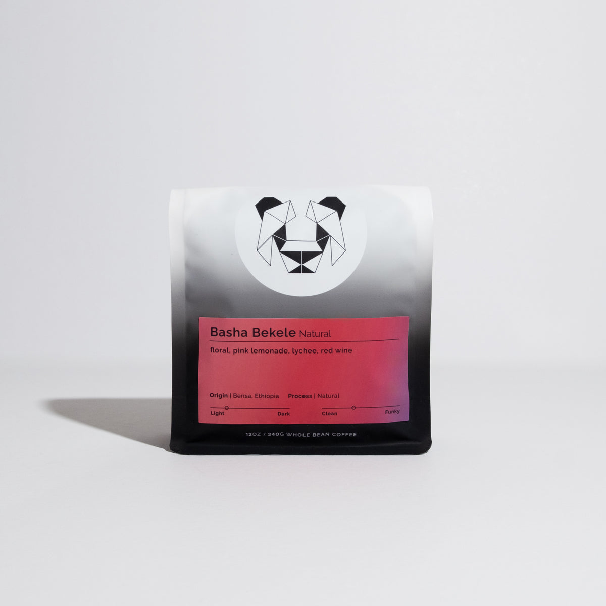 Bag of whole-bean coffee, Basha Bekele - Natural, highlighting floral, pink lemonade, lychee, red wine notes, with geometric logo and roast spectrum visible.