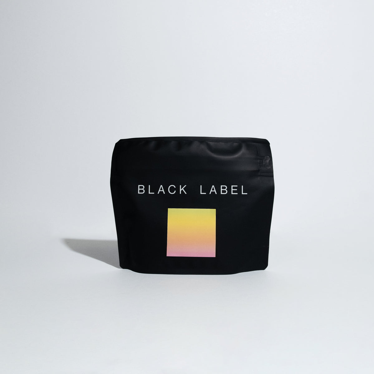 A black bag of coffee that says 'Black Label' on a white background with a multicolored label.