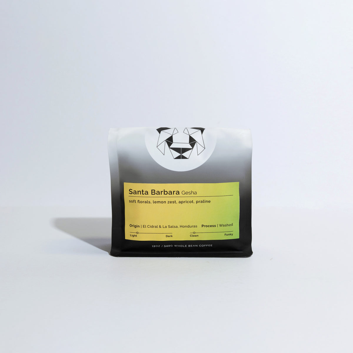 A bag of coffee on a white background with a yellow label that says Santa Barbara Gesha with tasting notes of soft florals, lemon zest, apricot, and praline.