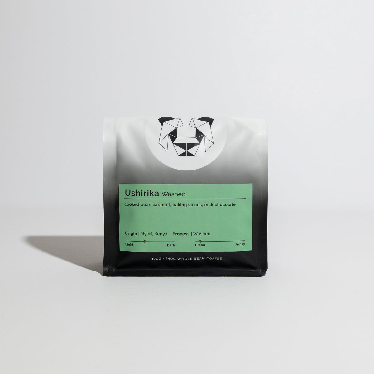 Bag of whole-bean coffee labeled “Ushirika - Washed” with tasting notes of cooked pear, caramel, and milk chocolate, origin Nyeri, Kenya.