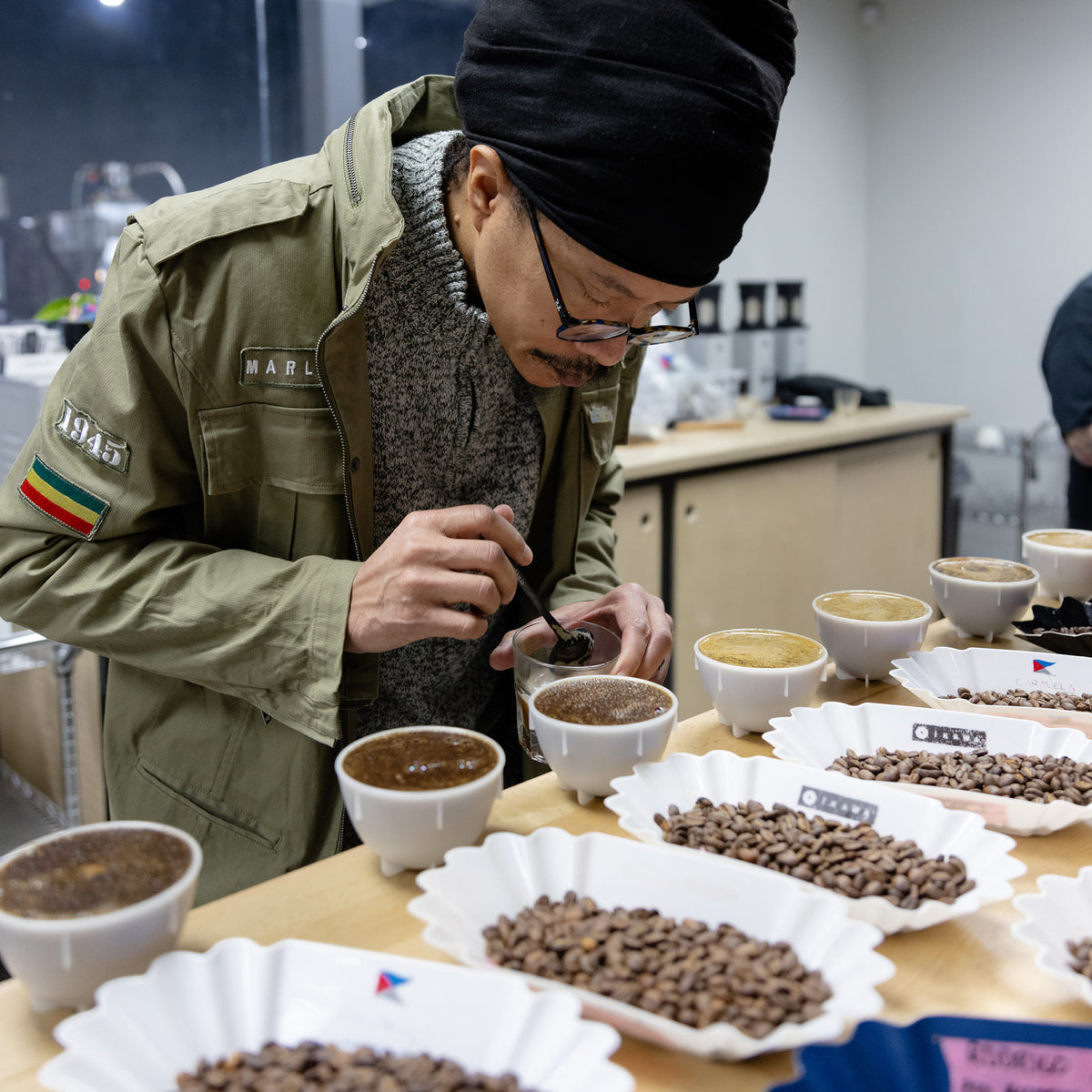 A  man cupping coffee in a modern cupping lab.
