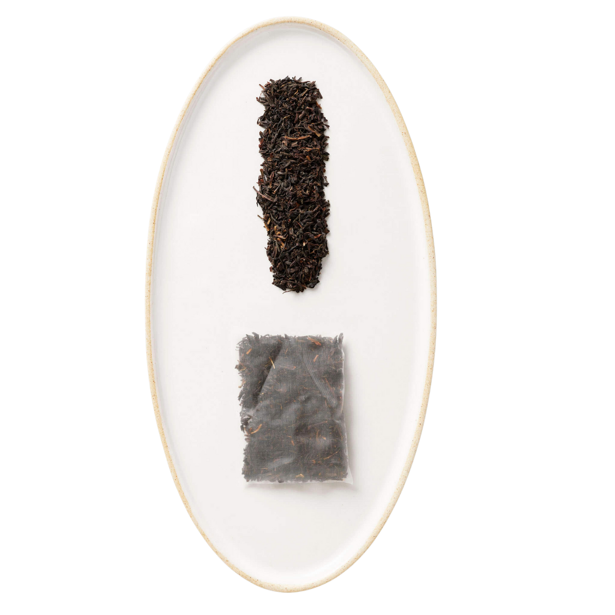 Two tea leaves on a white oval plate with a gold rim against a white background