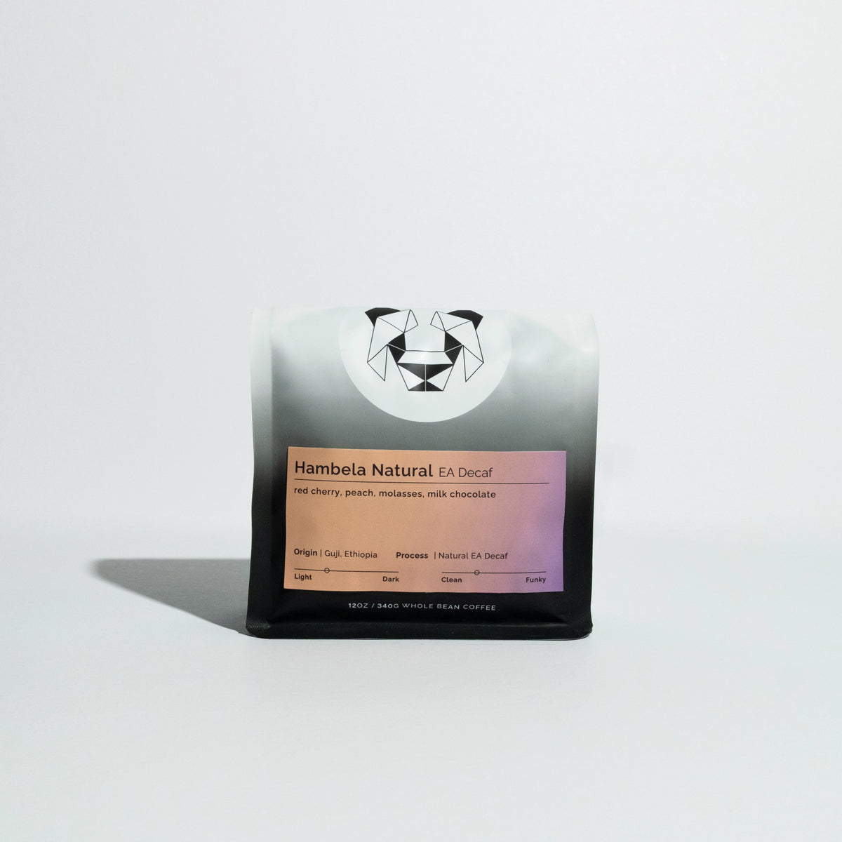Bag of Hambela Natural EA Decaf whole-bean coffee, 12 oz, featuring flavor notes of red cherry, peach, molasses, milk chocolate, and a geometric panda logo.