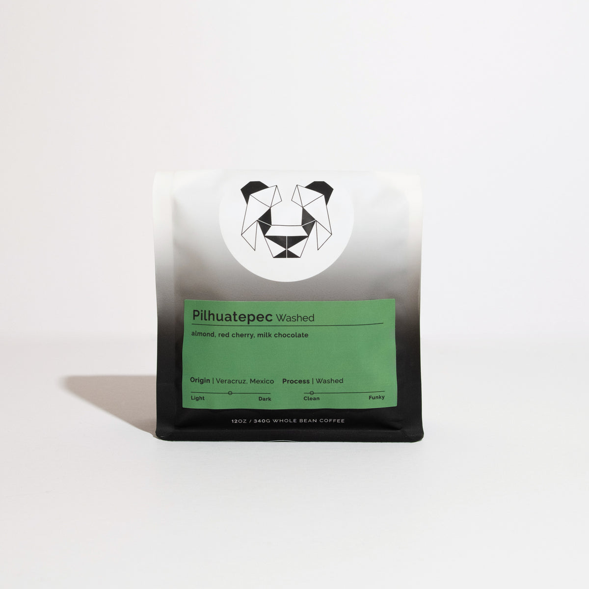 Pilhuatepec Washed coffee bag, 12 oz, featuring a geometric animal logo and green label. Noted flavors: almond, red cherry, milk chocolate. Origin: Veracruz, Mexico.