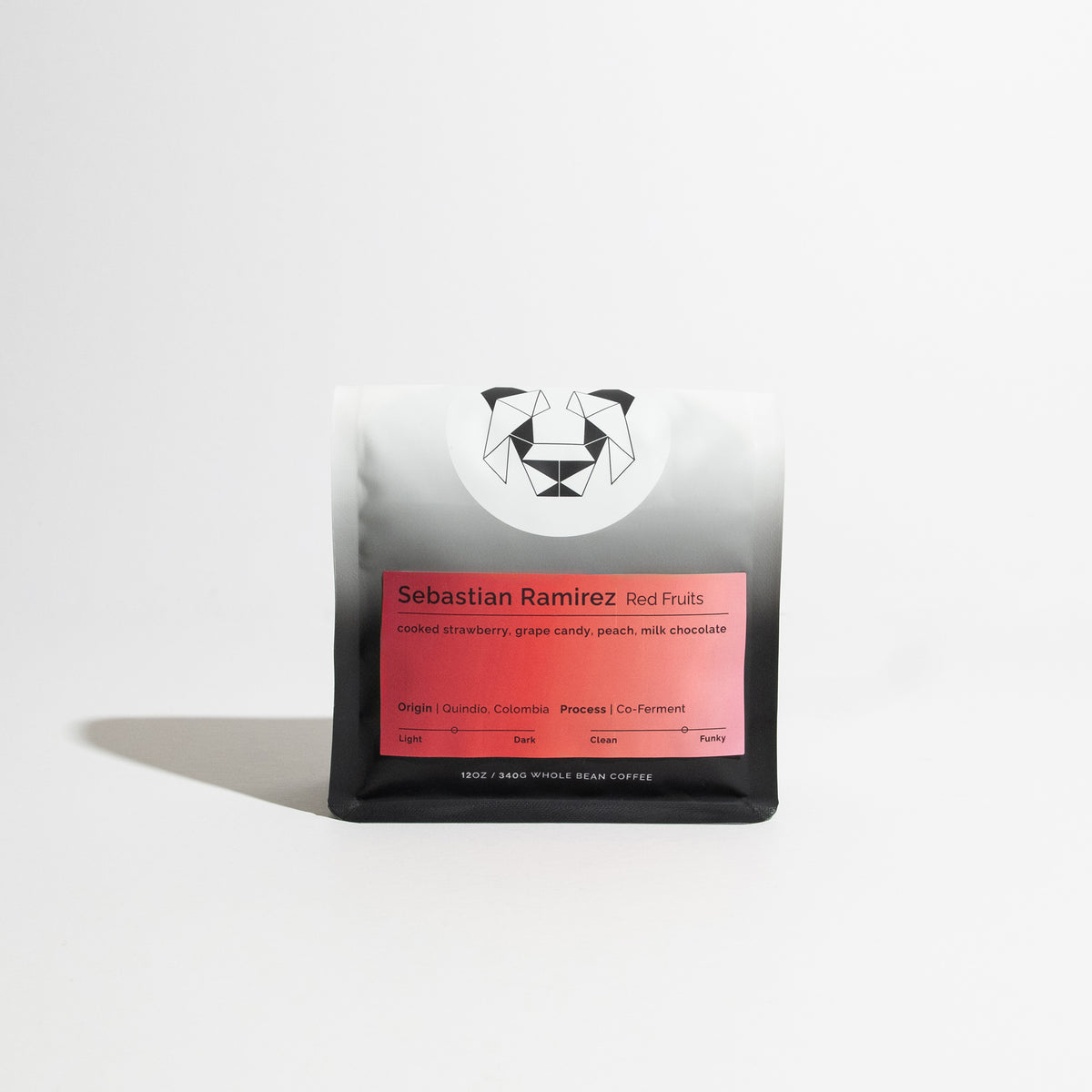 A bag of coffee on a white background with a red label that says Sebastian Ramirez Red Fruits with tasting notes of cooked strawberry, grape candy, peach, and milk chocolate.